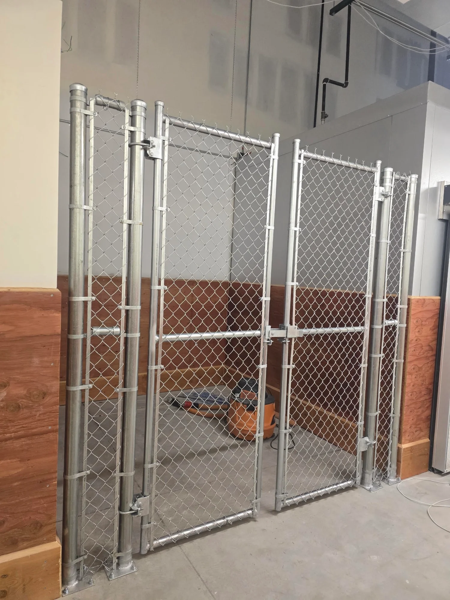 Galvanized chain-link security cage installed inside a Whole Foods Market